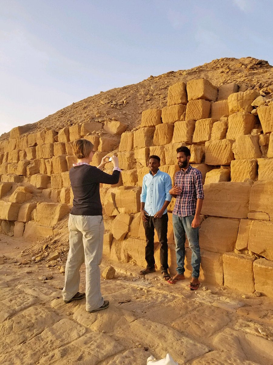 Three people at base of ruined pyramid
