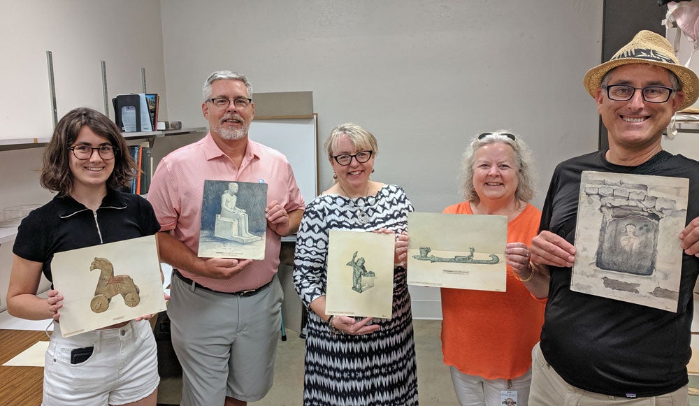 five people holding drawings