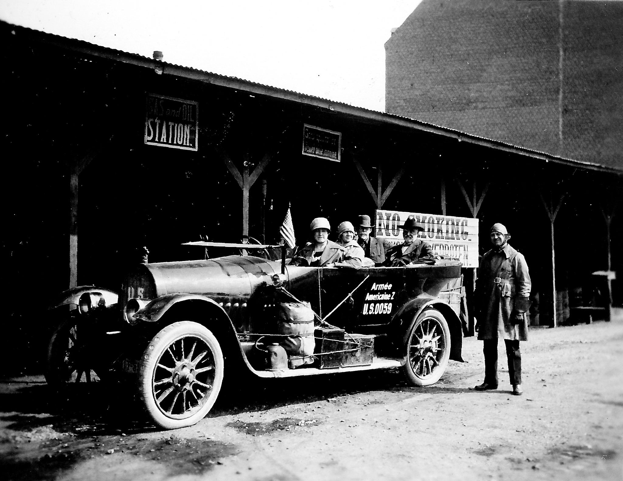 black and white photo of a 1920s car with passengers