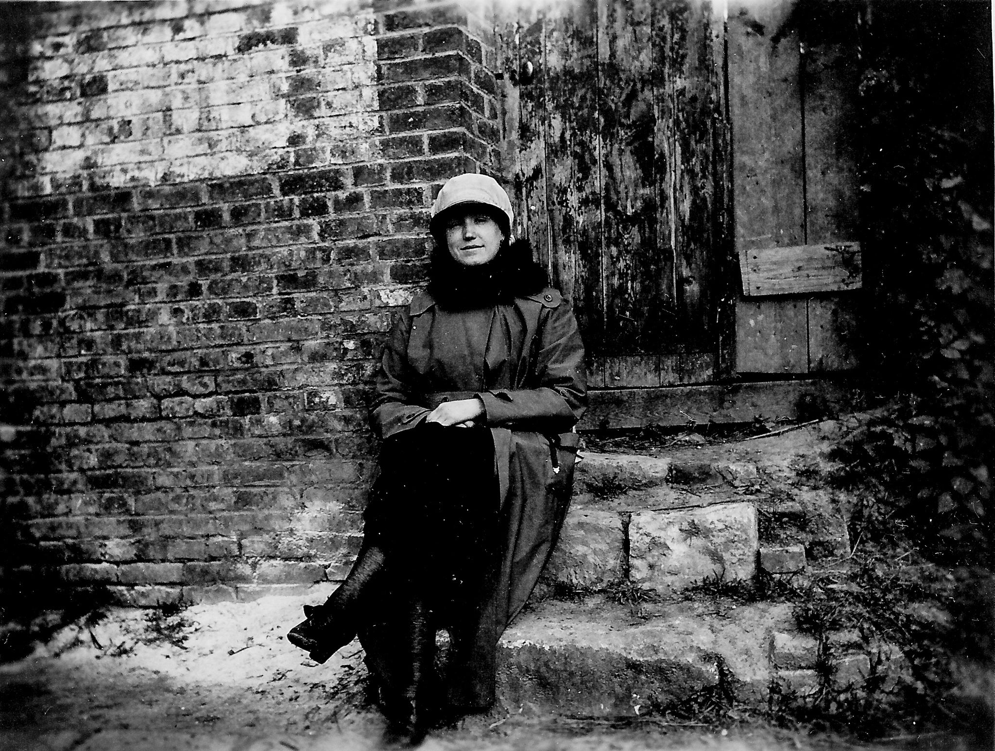 black and white photo of a woman seated on stone steps