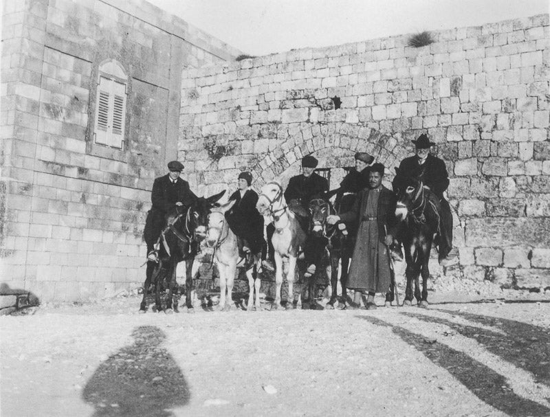black and white photo of tourists in Jerusalem on donkeys.