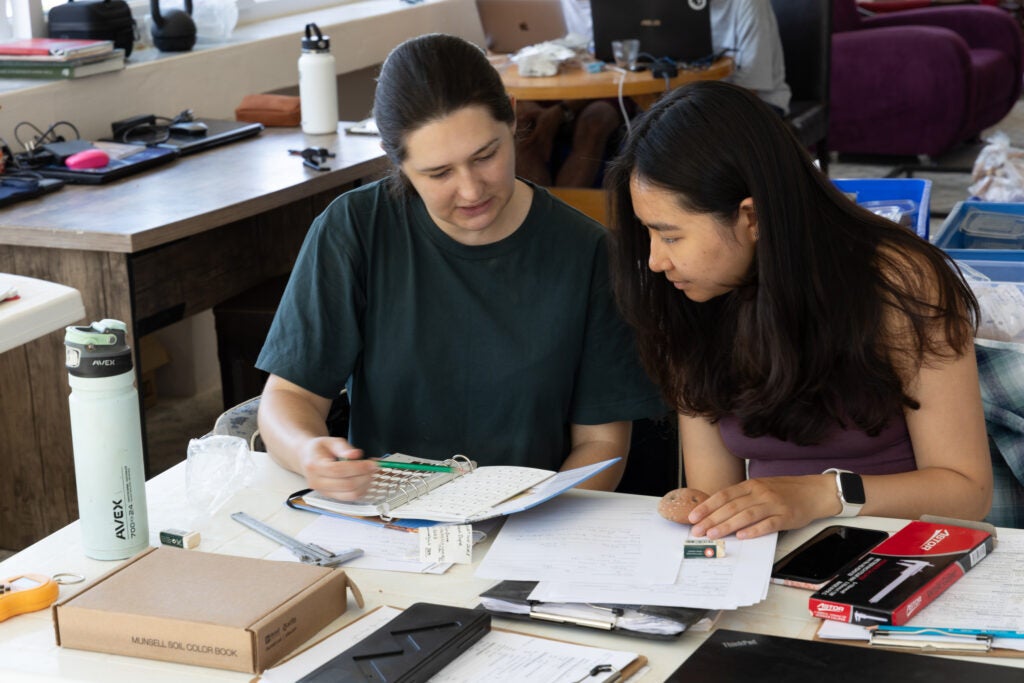 Archaeologists Christina DiFabio and Cecilia Huang working with artifacts