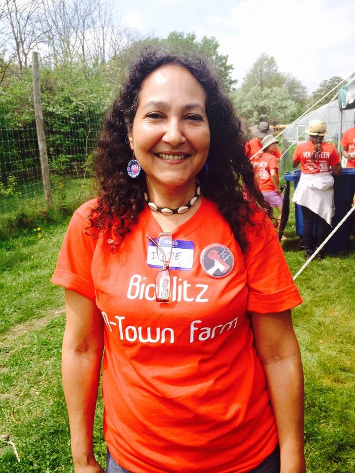 Professor Ivette Perfecto outside wearing a D-Town Farm shirt.