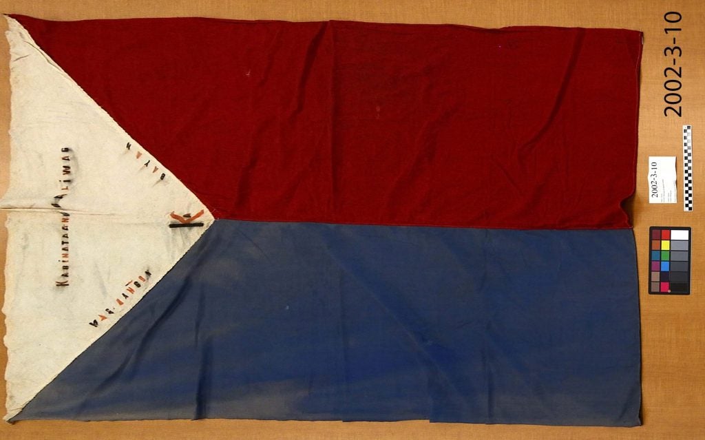 An image of what appears to be the Philippine flag, although it is altered in two ways. First, the red stripe has been placed on top of the blue stripe. Second, the stars and stripes of the flag have been replaced with words.
