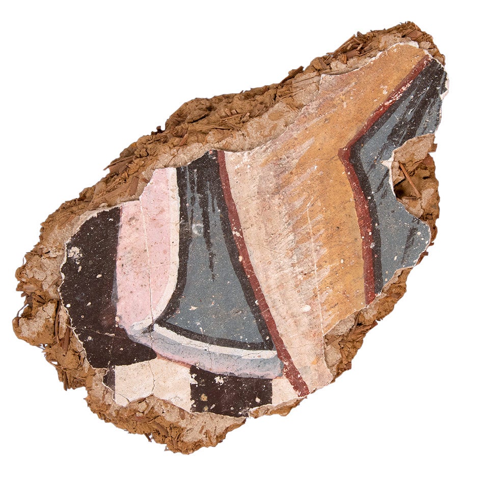Color photograph of a wall painting fragment depicting a bent leg and cape
