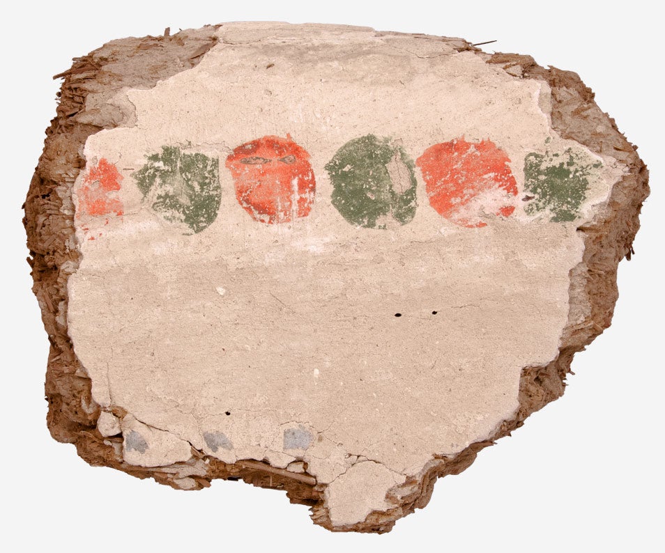 Color photograph of a wall painting fragment decorated with a series of red and green dots