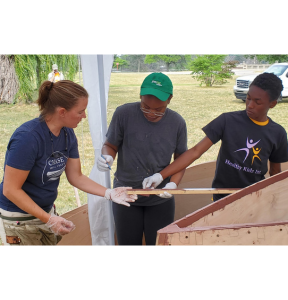 University of Michigan's Detroit River Story Lab. Woman guides students in building a skiff.