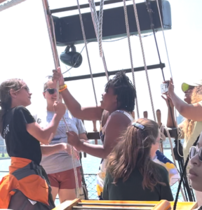 University of Michigan's Detroit River Story Lab. Girls hoisting the sail of a tall-masted ship on the Detroit River.