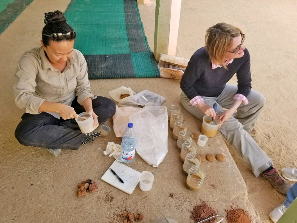 two women mixing mortar