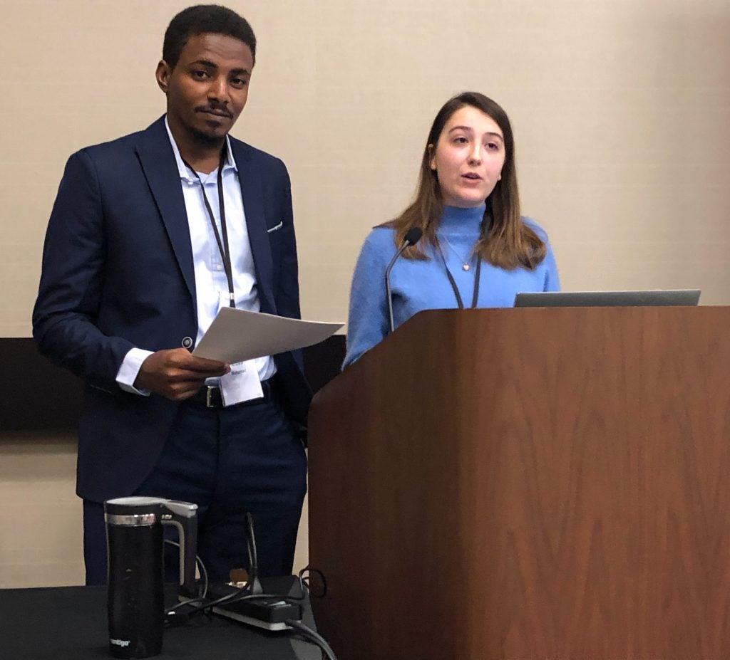 Anwar and Bailey Franzoi stand at podium co-presenting at the AIA conference.