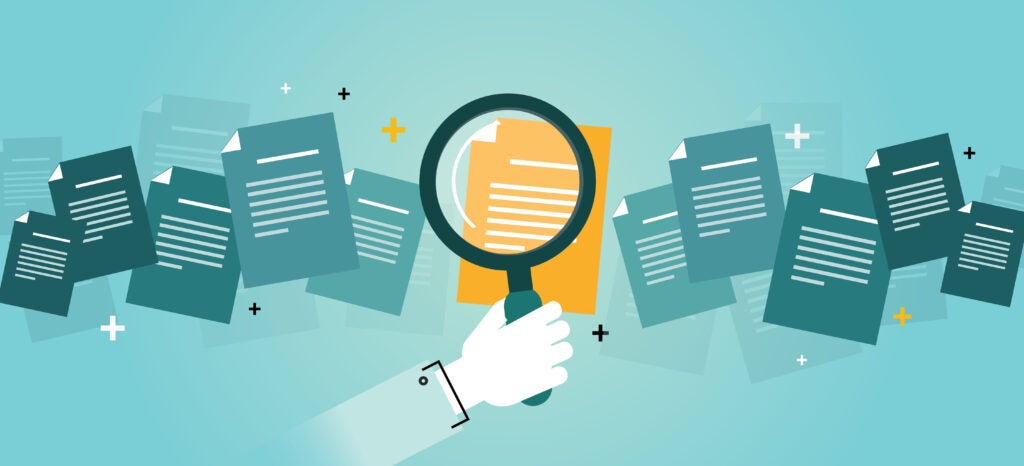 Magnifying glass looking at documents graphics