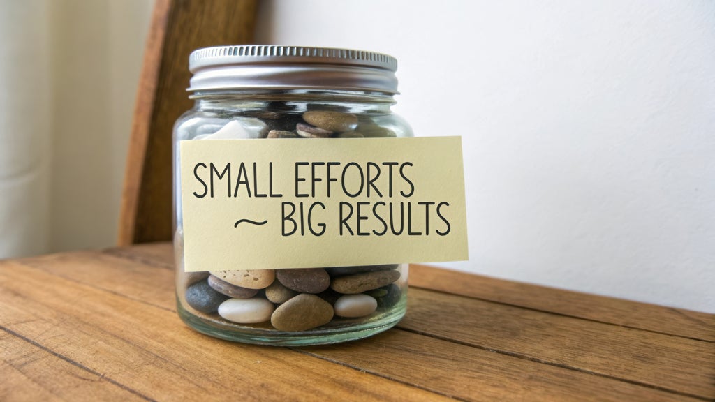 A glass jar filled with smooth pebbles sits on a wooden surface, symbolizing how small efforts can lead to significant results. A motivational note emphasizes the theme.
