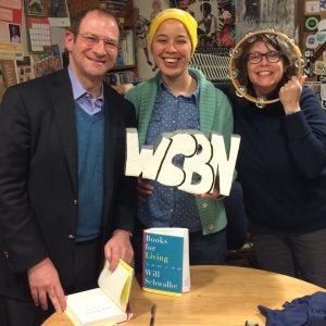 author photo with the Liz holding the WCBN sign and T with her face smiling through a tamborine