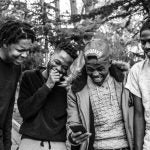 four young Black men laughing together